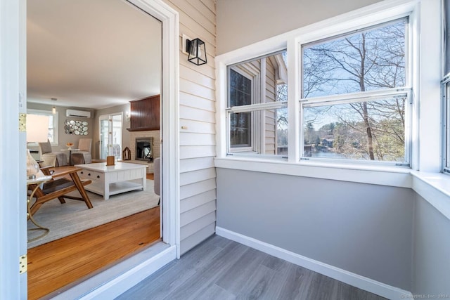 interior space featuring a wall mounted AC, wooden walls, and dark hardwood / wood-style flooring