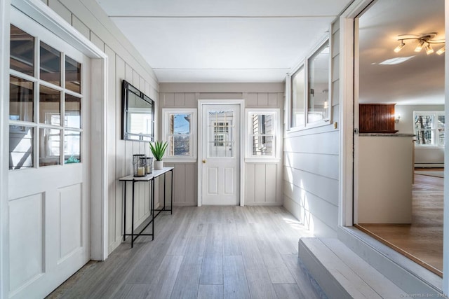 entrance foyer featuring light hardwood / wood-style flooring, a baseboard radiator, and a wealth of natural light