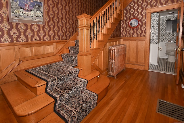 staircase featuring wood-type flooring and radiator