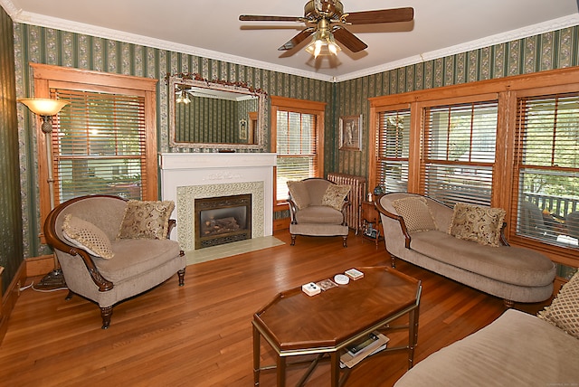 living room featuring ceiling fan, hardwood / wood-style flooring, and ornamental molding