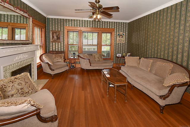 living room featuring crown molding, wood-type flooring, and ceiling fan