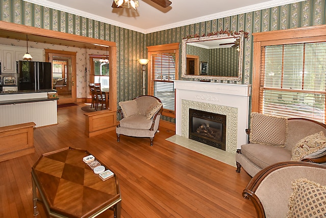 living room with crown molding, hardwood / wood-style flooring, and ceiling fan