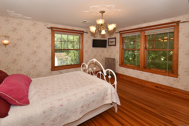 bedroom featuring wood-type flooring and a chandelier