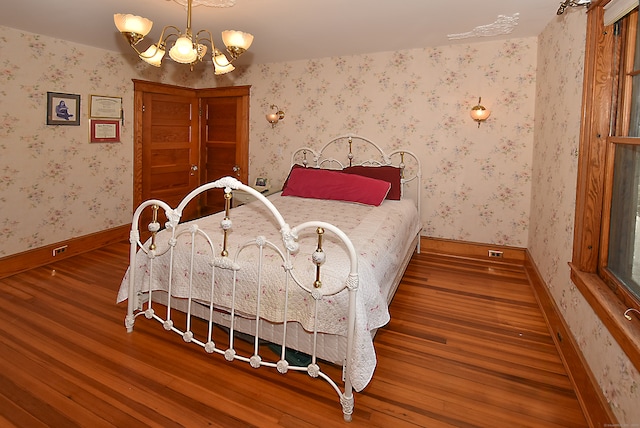 bedroom with a notable chandelier and hardwood / wood-style flooring