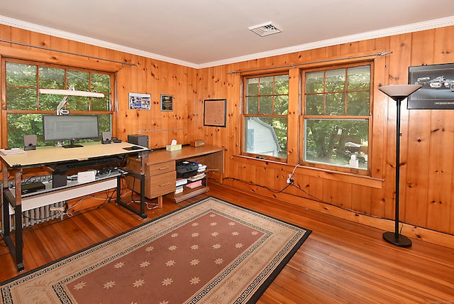 office featuring wood walls, ornamental molding, hardwood / wood-style floors, and plenty of natural light