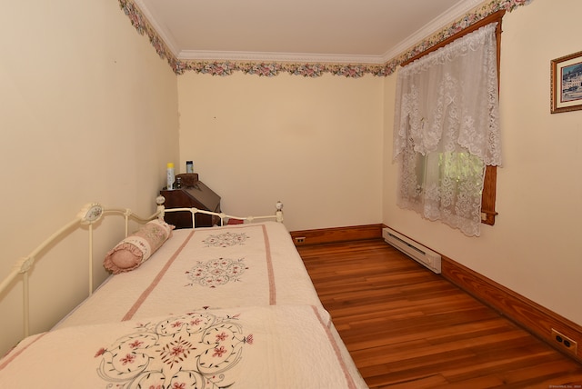 bedroom with crown molding, wood-type flooring, and a baseboard heating unit