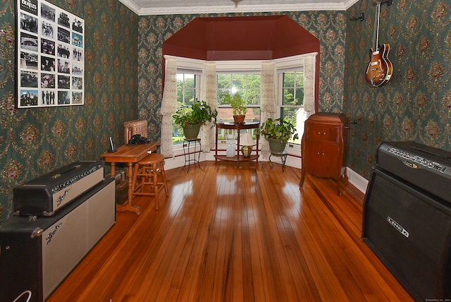 sitting room with crown molding and wood-type flooring