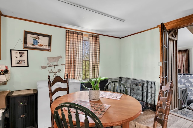 dining space with light hardwood / wood-style floors and ornamental molding