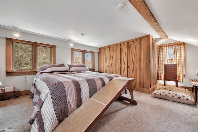 bedroom with vaulted ceiling with beams and light colored carpet