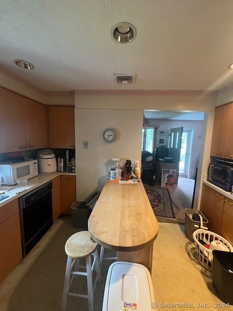 kitchen featuring black dishwasher and a textured ceiling