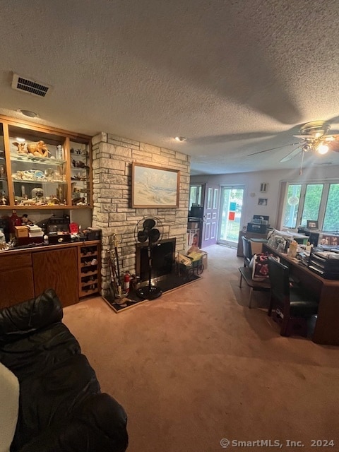 living room with a textured ceiling, carpet, and ceiling fan