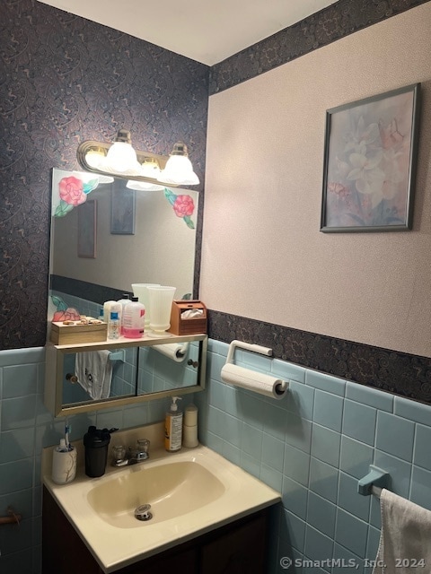 bathroom featuring vanity and tile walls