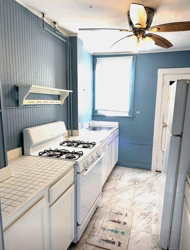 kitchen featuring tile countertops, white cabinets, sink, ceiling fan, and white appliances