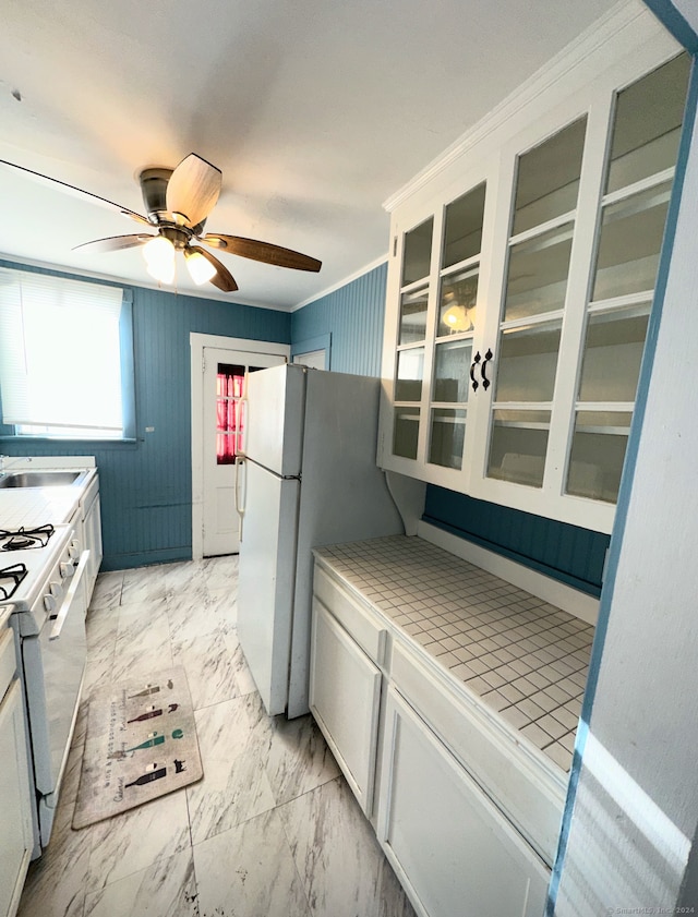 kitchen featuring white cabinetry, ceiling fan, white appliances, crown molding, and tile counters