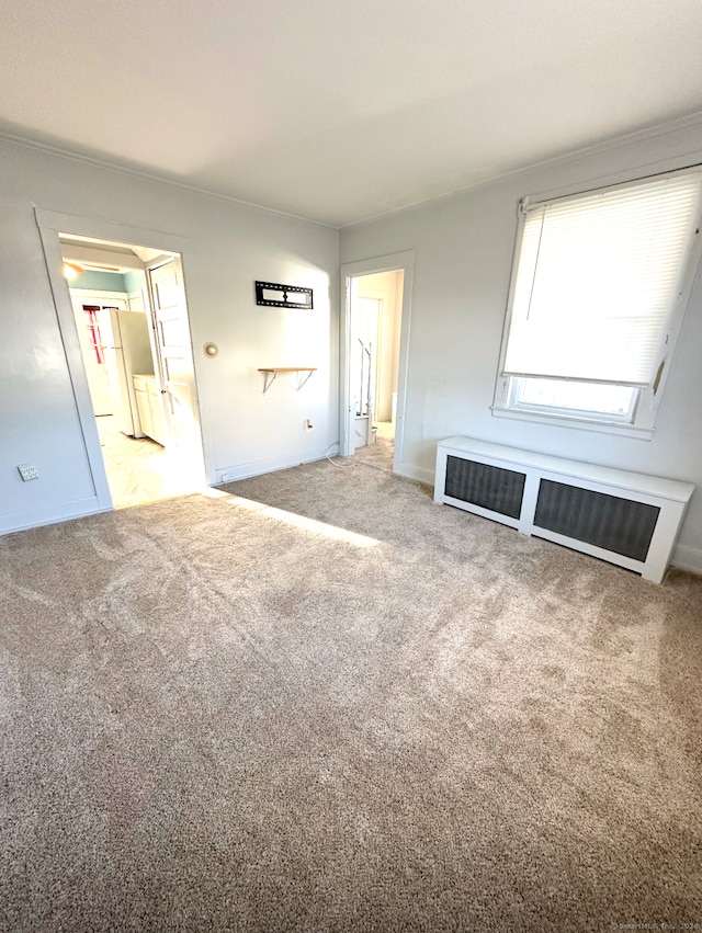 carpeted spare room featuring radiator