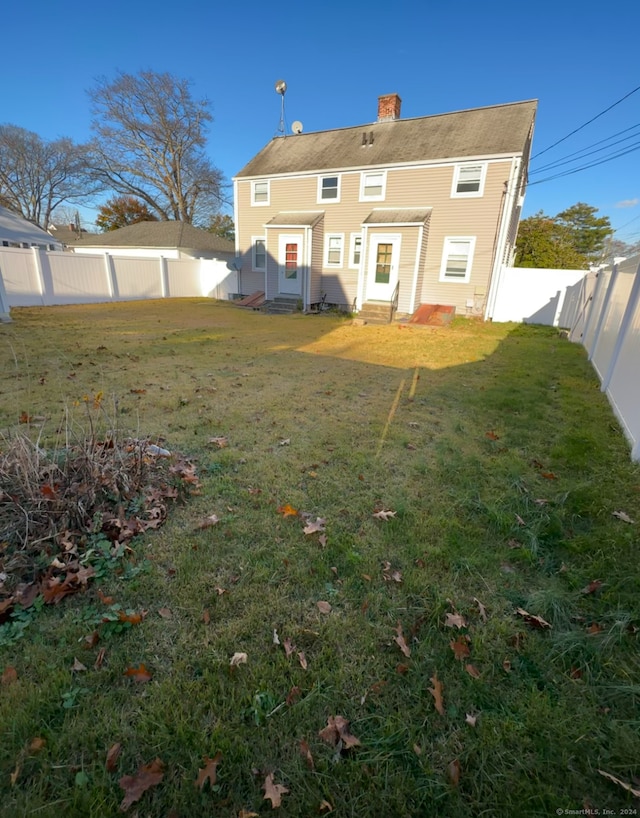 rear view of property featuring a lawn