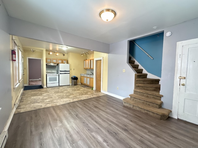 unfurnished living room featuring hardwood / wood-style floors and a baseboard radiator