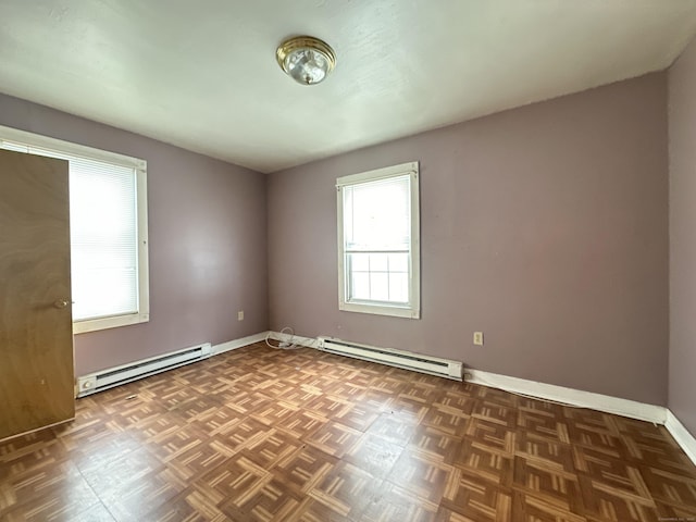 unfurnished room with dark parquet flooring and a baseboard radiator