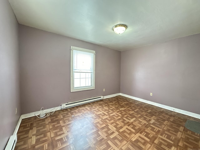 spare room featuring dark parquet flooring and baseboard heating