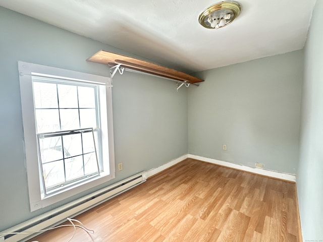 spare room featuring a baseboard radiator and light hardwood / wood-style flooring