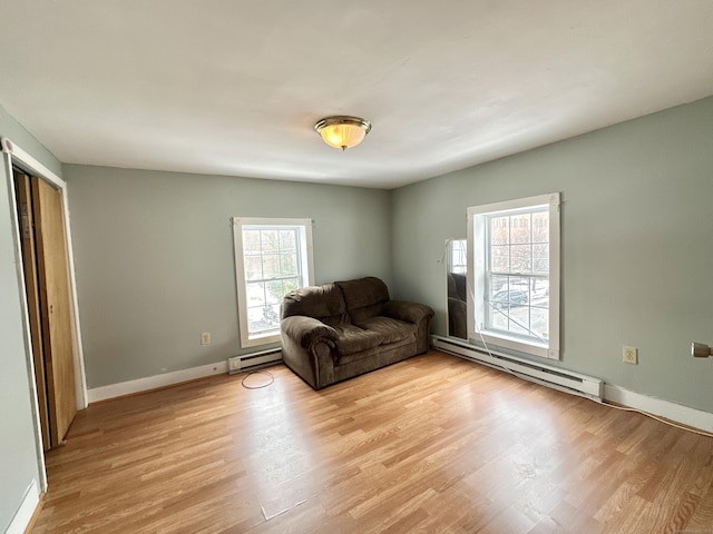 unfurnished living room with baseboard heating and light hardwood / wood-style floors