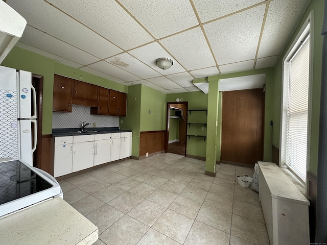 kitchen with a drop ceiling, sink, white appliances, and a healthy amount of sunlight