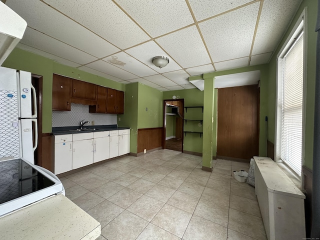 kitchen with white appliances, sink, a paneled ceiling, and a wealth of natural light