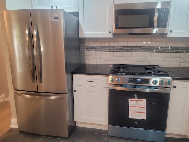 kitchen with stainless steel appliances, white cabinets, and decorative backsplash