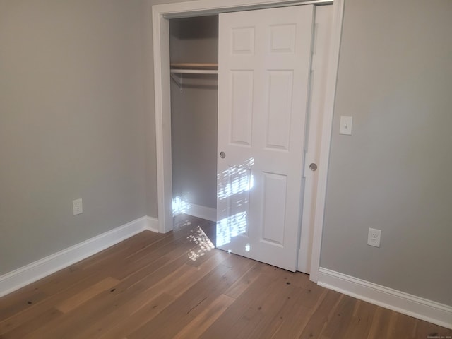 unfurnished bedroom with hardwood / wood-style flooring and a closet