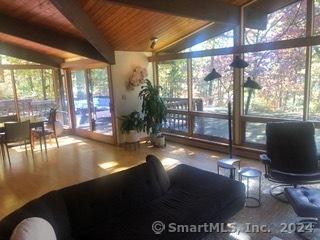 interior space with lofted ceiling with beams, plenty of natural light, expansive windows, and wood ceiling