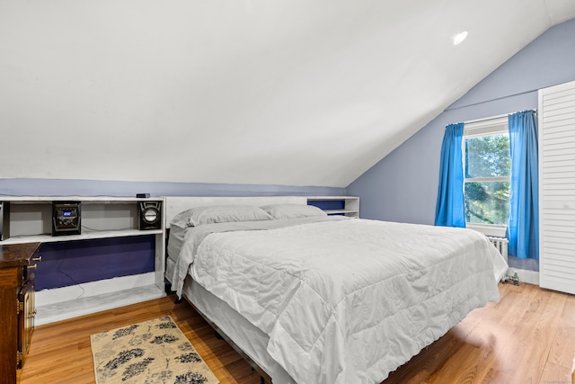 bedroom featuring hardwood / wood-style floors and lofted ceiling