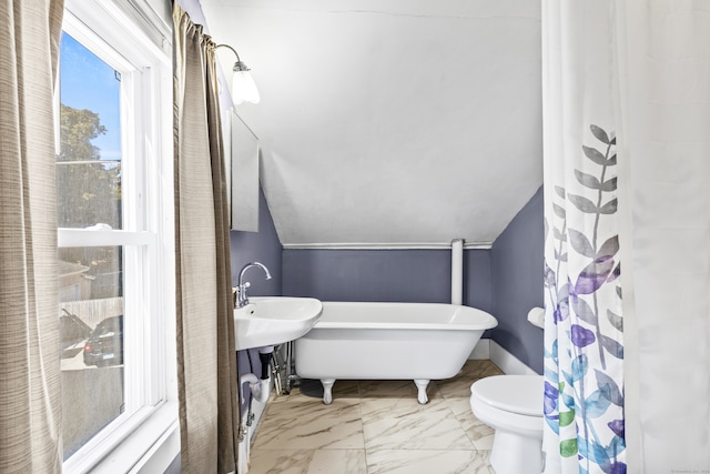 bathroom with toilet, a bathtub, and lofted ceiling