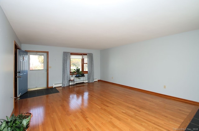 empty room featuring hardwood / wood-style floors and a baseboard radiator