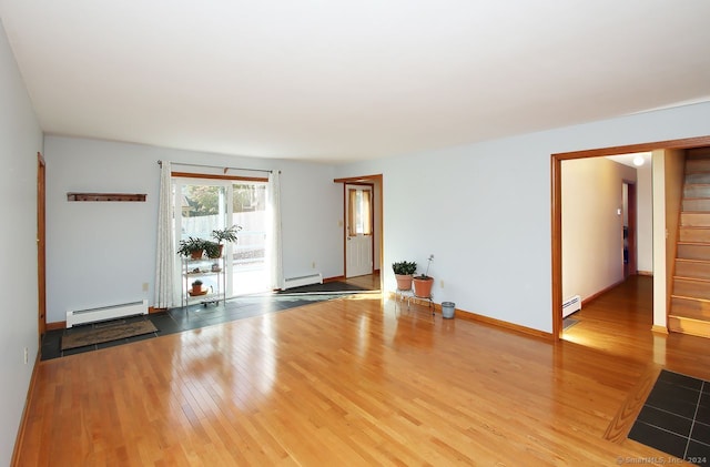 unfurnished room featuring hardwood / wood-style floors and a baseboard radiator