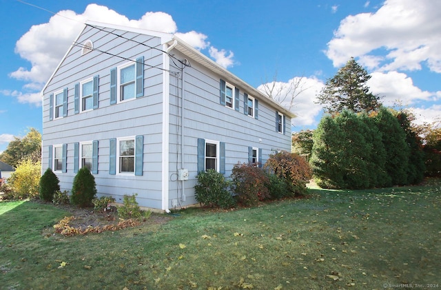 view of property exterior with a lawn