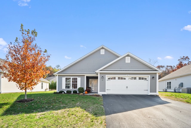 view of front of property featuring a front yard, central AC, and a garage