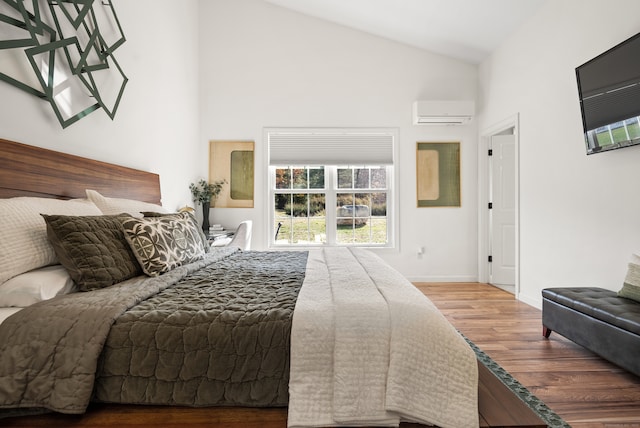 bedroom with hardwood / wood-style floors, a wall mounted air conditioner, and high vaulted ceiling