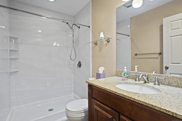 bathroom featuring vanity, toilet, and a shower