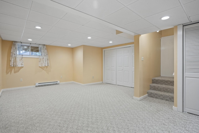 basement featuring carpet flooring and a baseboard heating unit