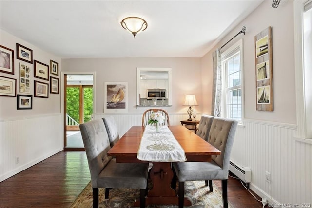 dining area featuring dark hardwood / wood-style flooring and a baseboard heating unit