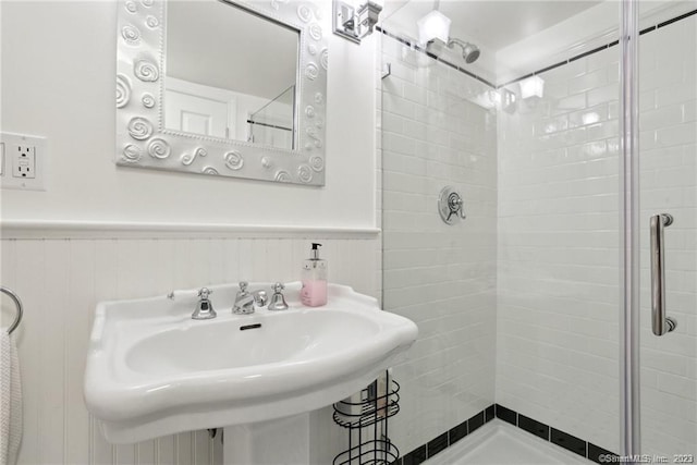 bathroom with sink and a shower with shower door