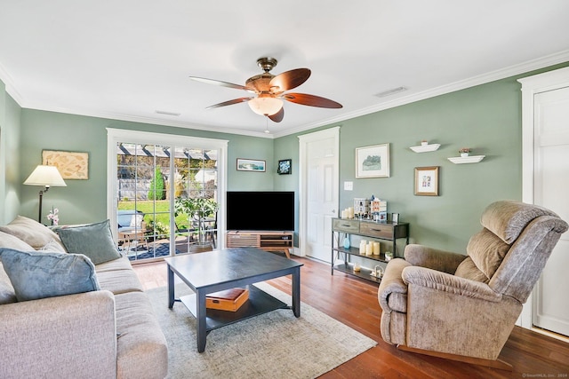 living room featuring a ceiling fan, crown molding, visible vents, and wood finished floors