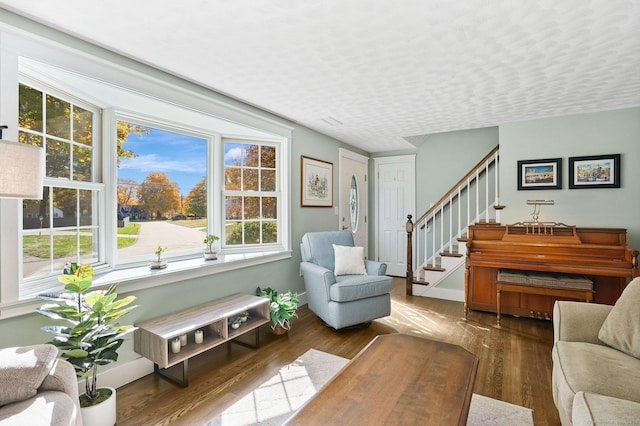 sitting room with stairway, baseboards, and wood finished floors