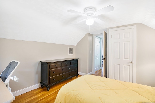 bedroom with lofted ceiling, ceiling fan, light wood-style flooring, visible vents, and baseboards