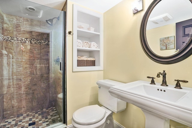 bathroom with built in features, visible vents, toilet, a stall shower, and a sink