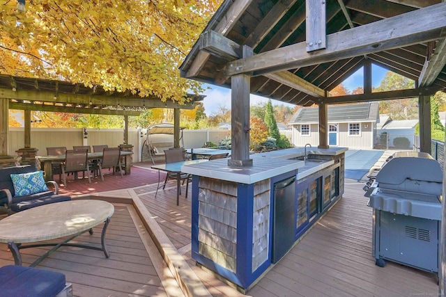 wooden terrace featuring an outbuilding, outdoor dining area, outdoor dry bar, fence, and a shed