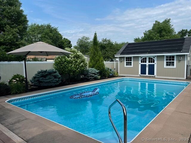 view of pool featuring a fenced in pool, fence, and an outdoor structure