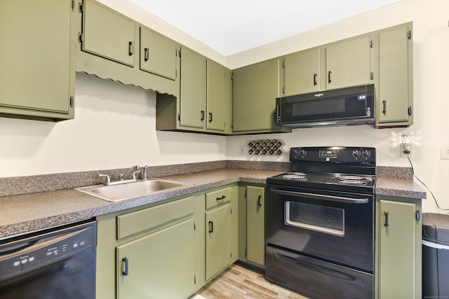 kitchen featuring light hardwood / wood-style flooring, black appliances, sink, and green cabinets