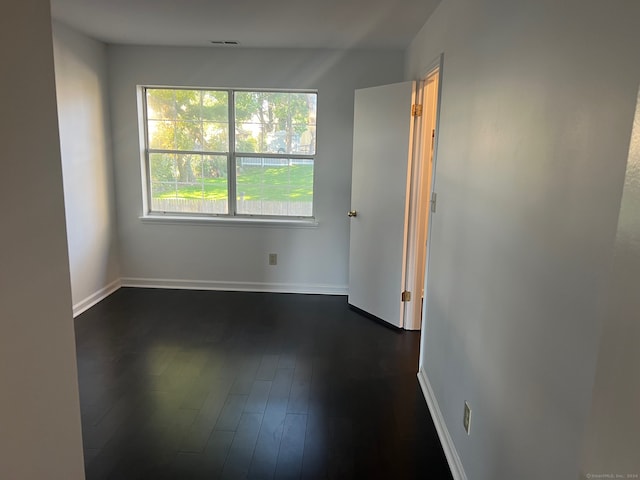 unfurnished room featuring dark wood-type flooring