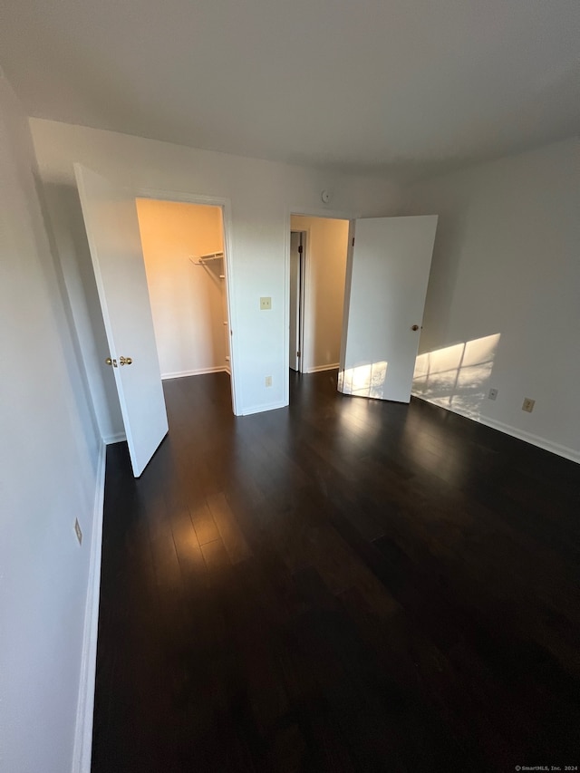 unfurnished room with dark wood-type flooring